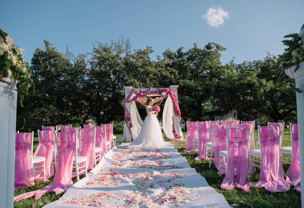 beautiful young bride standing near arch at the wedding ceremony